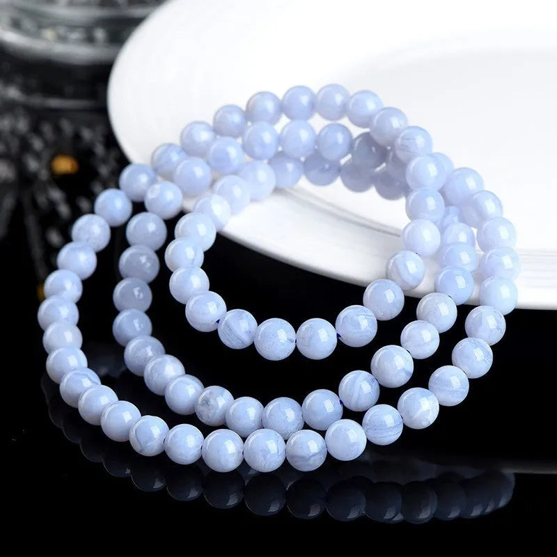Blue agate beaded bracelet with multi-circle patterns and Ruyi design elements on a wrist.