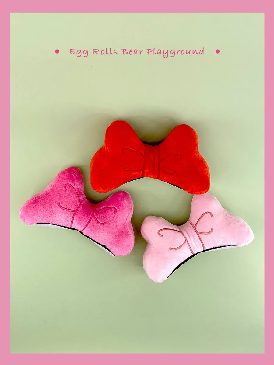 Soft plush bow helmet decoration with pom-pom in red, pink, and peach colour options.