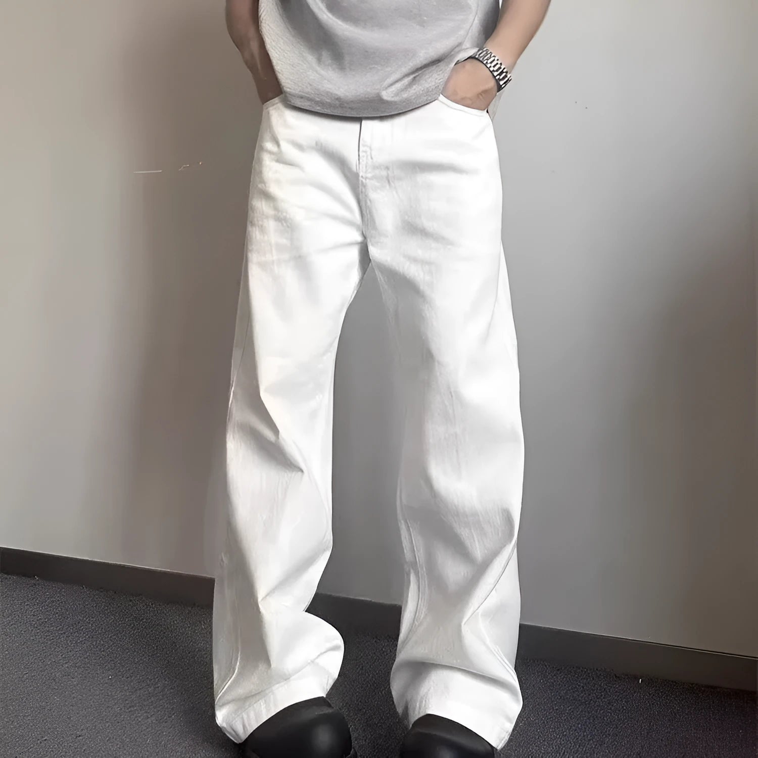 Men's white straight-leg denim jeans with a wide leg opening and a zip fly.