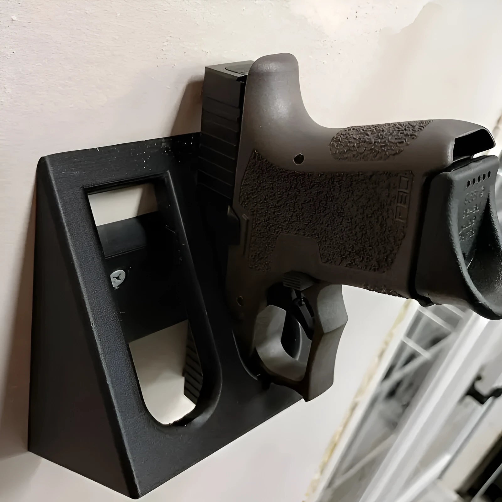Black plastic pistol display stand with punk-style design measuring 10.85 by 7.6 centimetres