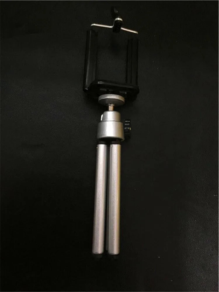 Black desktop phone holder with two-section bracket arm on wooden desk