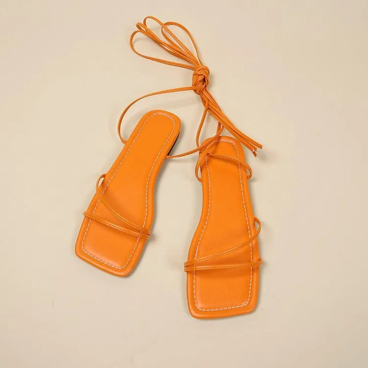 Women's flat sandals with a black PU upper, ankle ring bandage strap, front lace-up, and square toe.