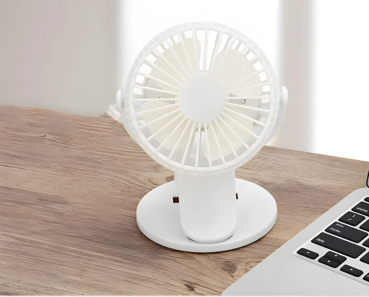 Small white USB rechargeable clip fan with brushless motor attached to a desk edge.