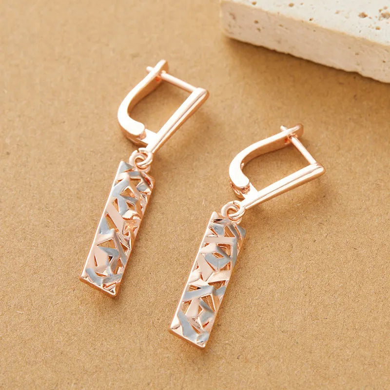 A pair of rectangular two-tone hollow stud earrings with an electroplated finish on a white background.