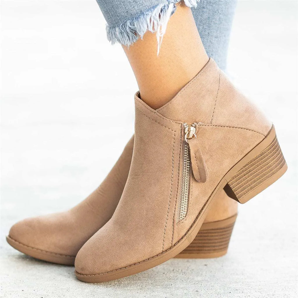Women's suede ankle boots with a side zip and chunky heel in beige, shown from the side.
