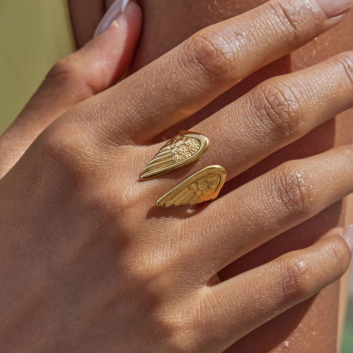 Stainless steel wings ring with an opening adjustable design on a white background.