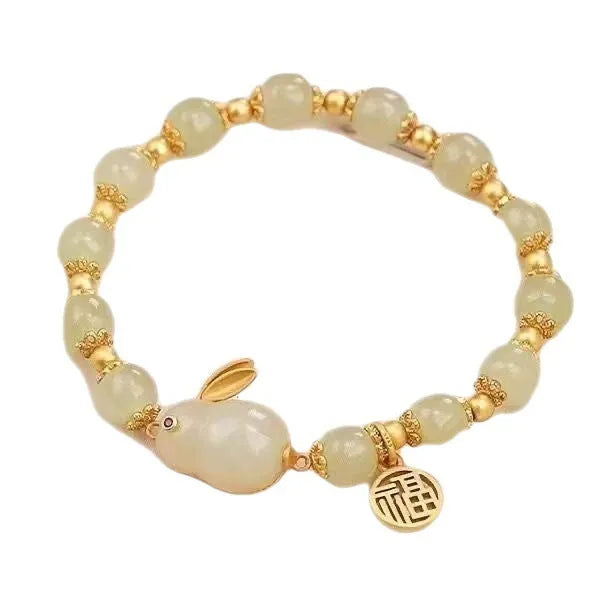 Women's green jade bracelet with black hand charm and hare pendant featuring fu character and lily motifs