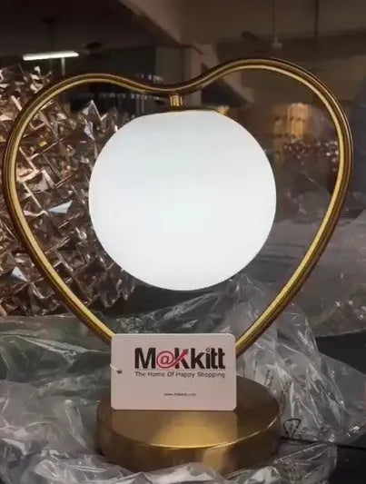 Heart shaped white LED bedside lamp with touch dimmer controls on a wooden table.