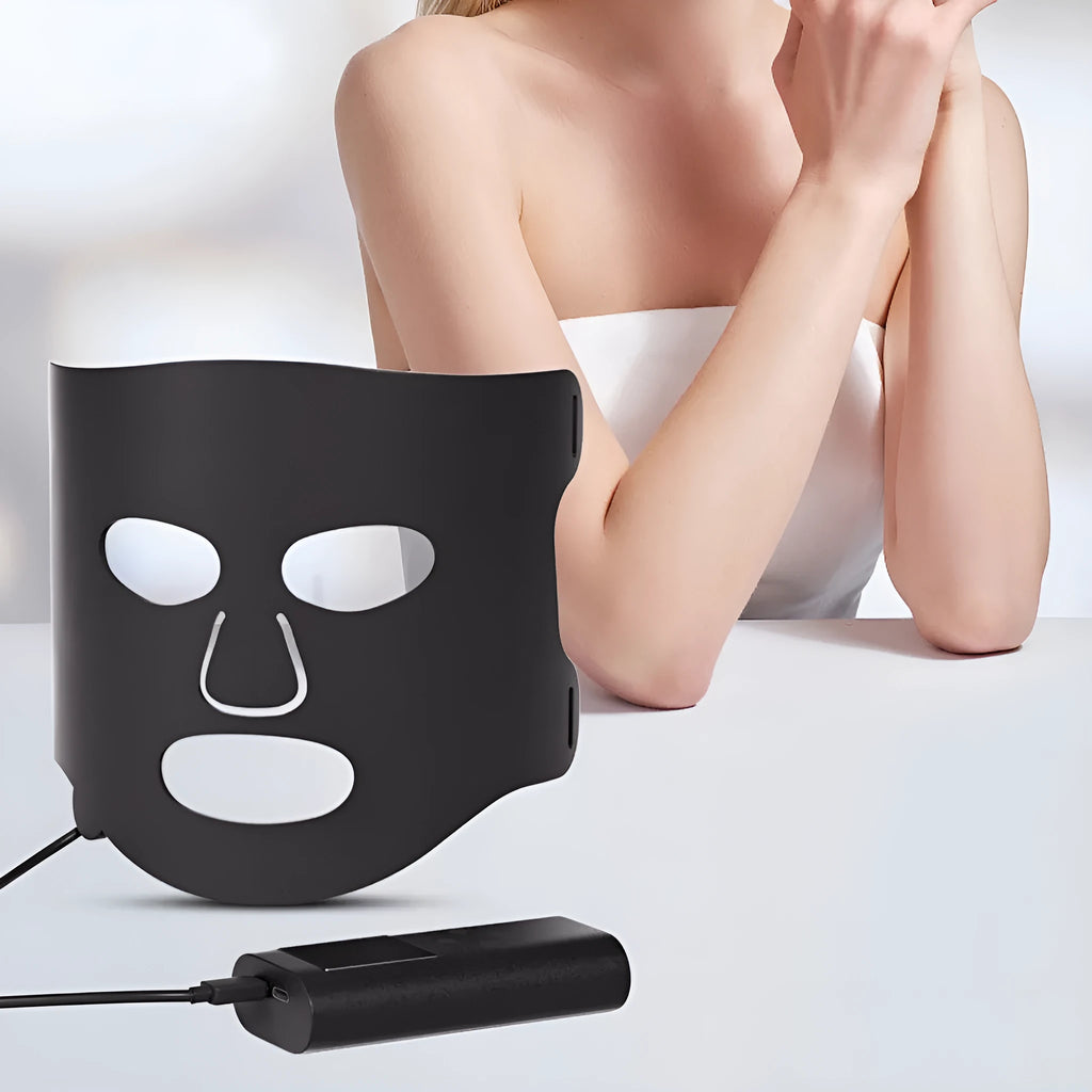 Black and white LED phototherapy face mask with controller for home skin treatment.