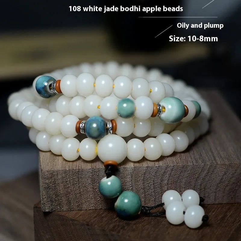 White jade bodhi seed bracelet with 108 flat round beads on a wrist.