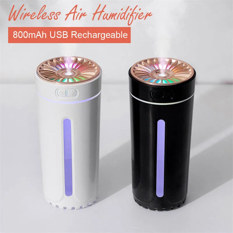 Black wireless ultrasonic humidifier with colourful lights, shown next to a USB cable on a desk.