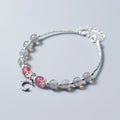 Handmade adjustable moonstone bracelet with a silver crescent moon charm and clear crystal accent on a grey background.