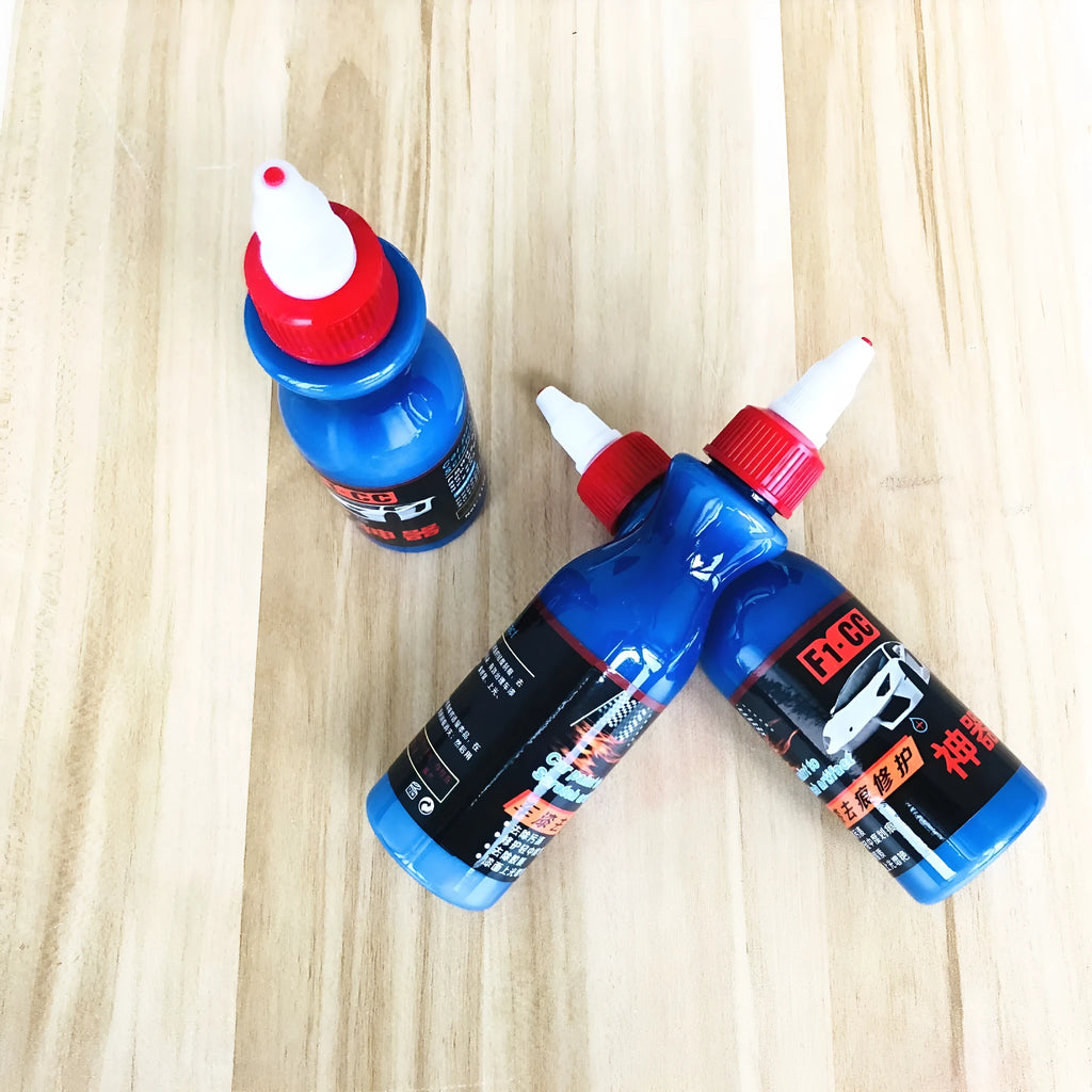 Blue car scratch repair kit with bottle of repair agent and application tool for automotive paint touch-ups