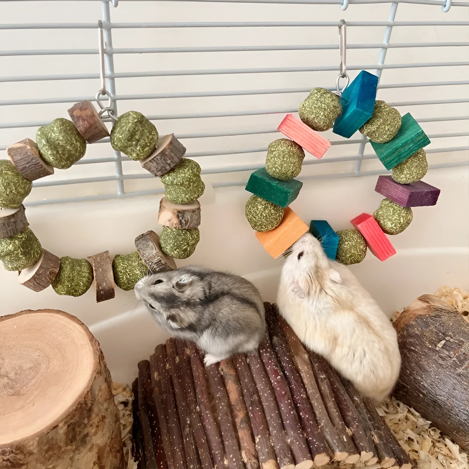 Small pet chew toy showing a ring with a decorative straw ball, in either sequin or applewood style.