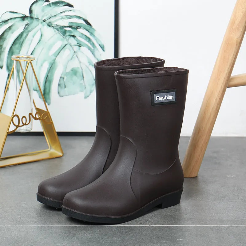 Women's mid-calf PVC rain boot in black on a wet surface