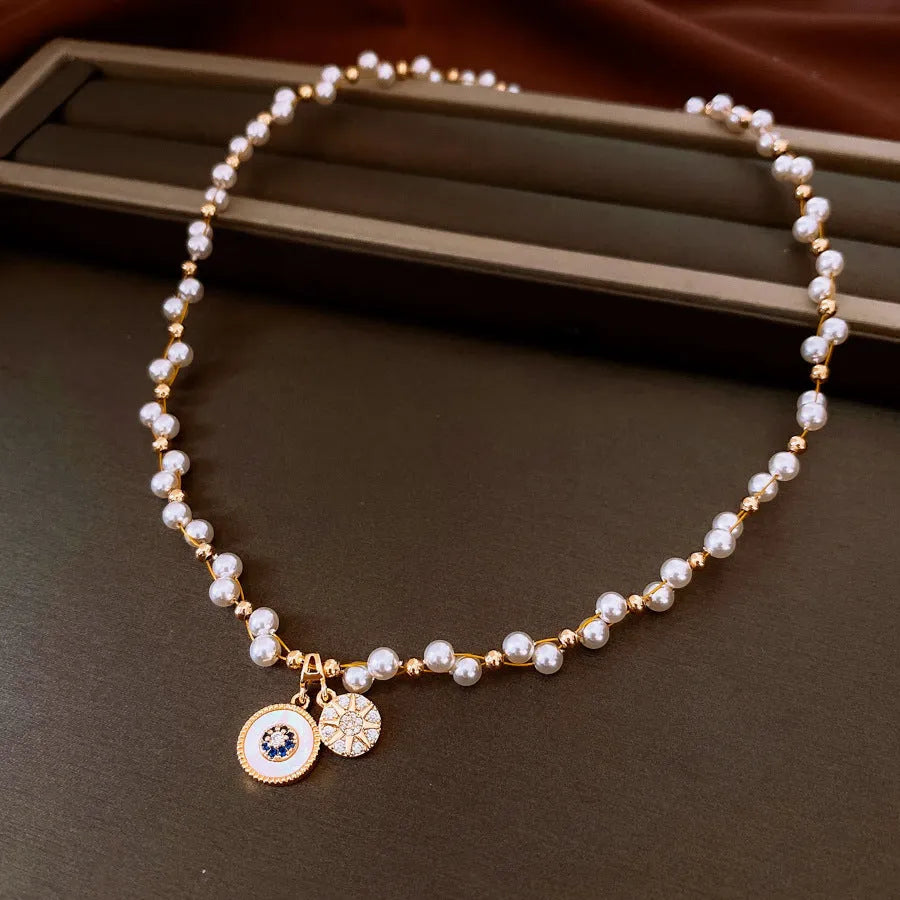 Gold electroplated round pendant necklace with inlaid zircon stone on a clavicle chain