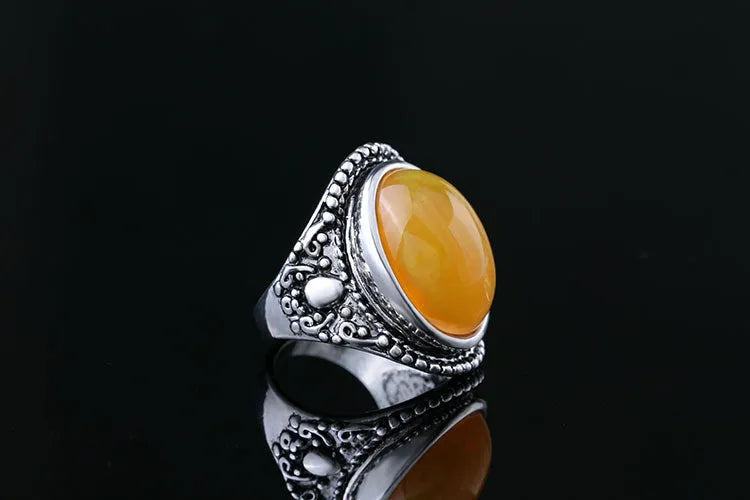 Geometric retro-style alloy ring in antique silver amber colour on a finger.