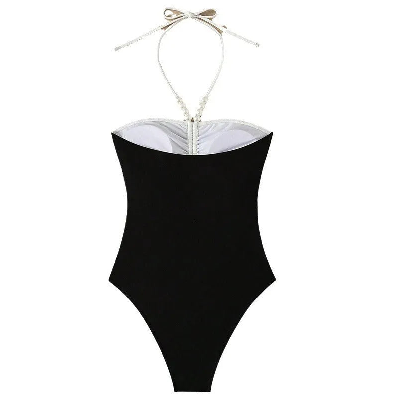 Black and white women's one-piece swimsuit with spaghetti straps and slimming cut