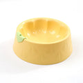 Green plastic flower-shaped double pet bowl for food and water on a white background.