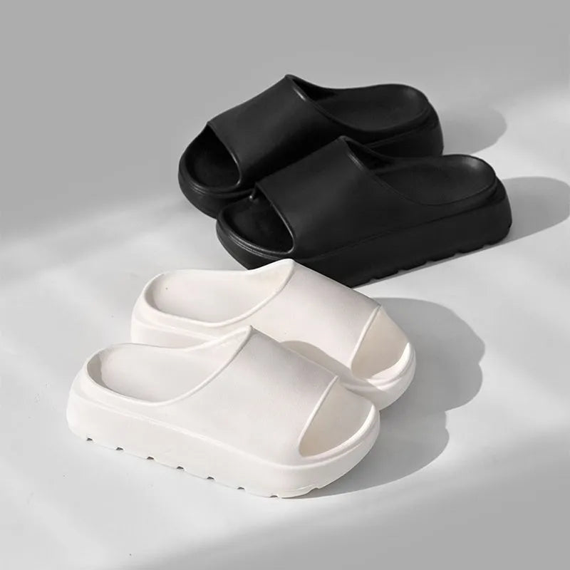 Women's thick-soled EVA beach slippers in beige, shown from the side on a sandy surface.