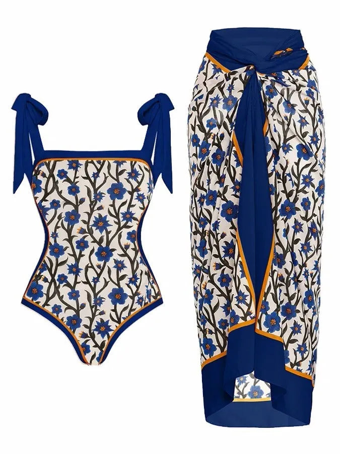 Women's floral print two-piece swimsuit with a sheer black chiffon hip skirt overlay.