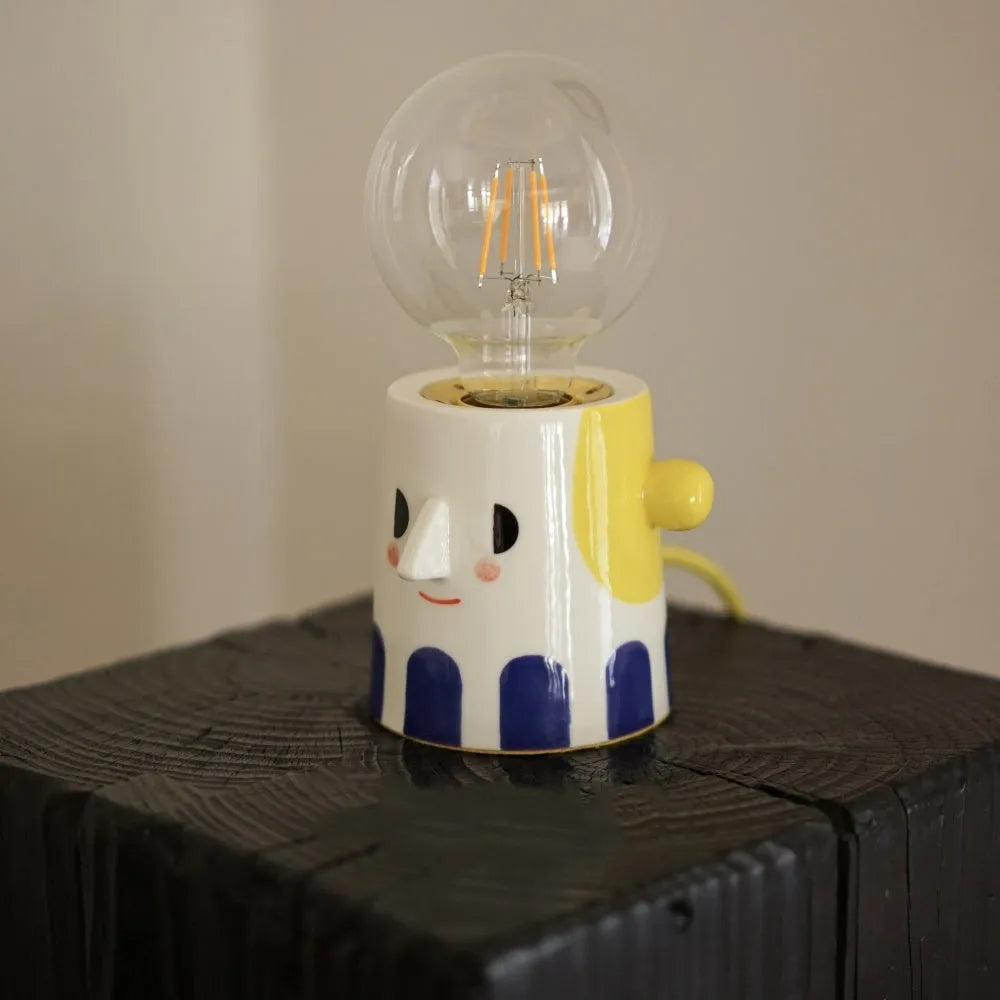 Handmade ceramic table lamp with ball-shaped shade on wooden surface