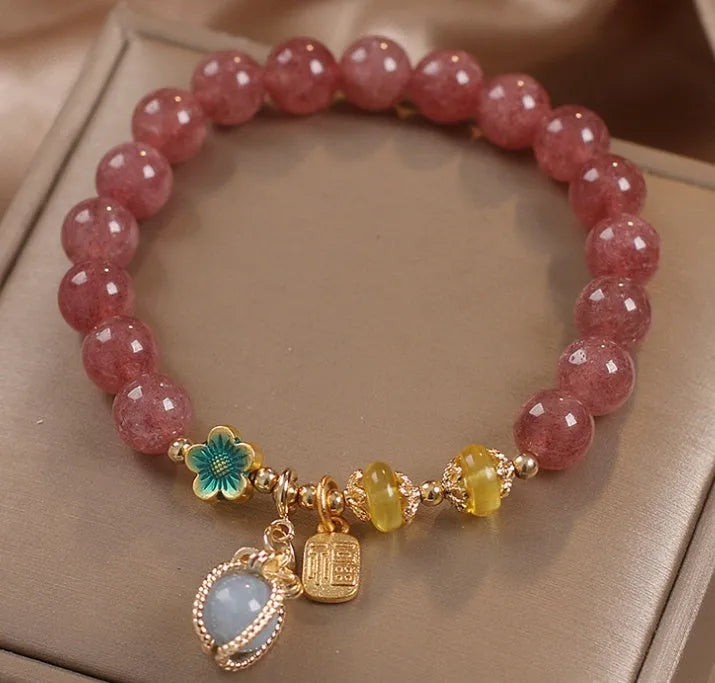 Red women's bracelet with strawberry quartz beads, alloy metal elements, and rhinestone decorative details on adjustable band
