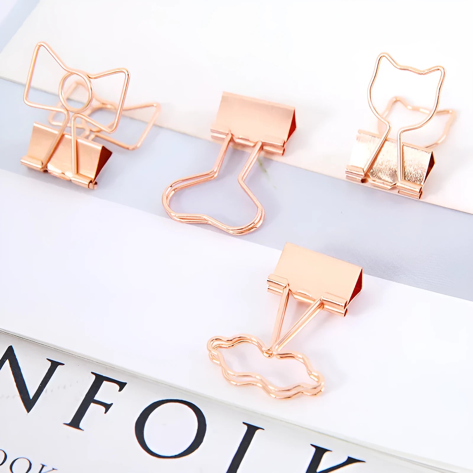 Gold plated decorative paper clip in a choice of flamingo, love, cloud, cat, cactus, or bow designs on a white background.