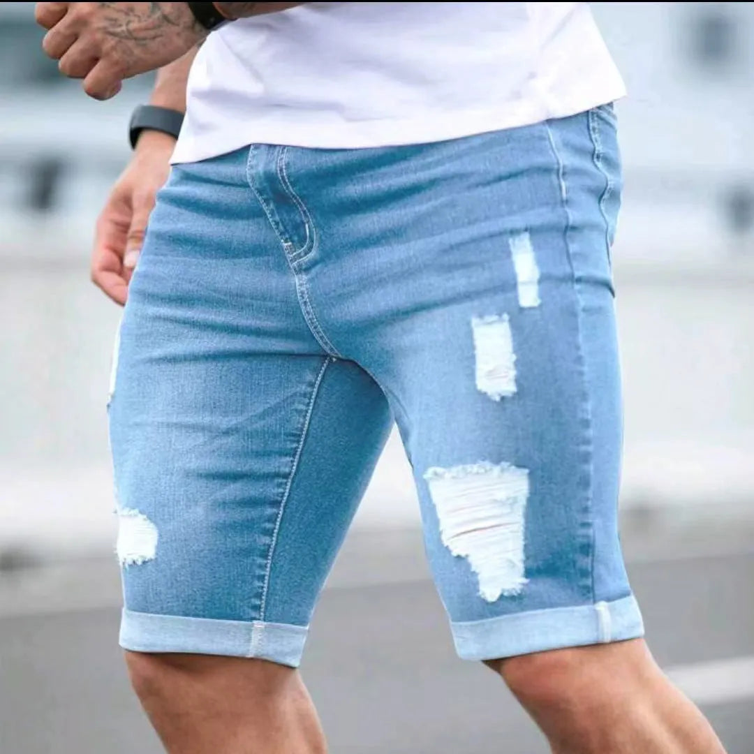 Sky blue men's denim shorts with multi-hole distressing on the legs, showing a low-rise waist and zipper fly.