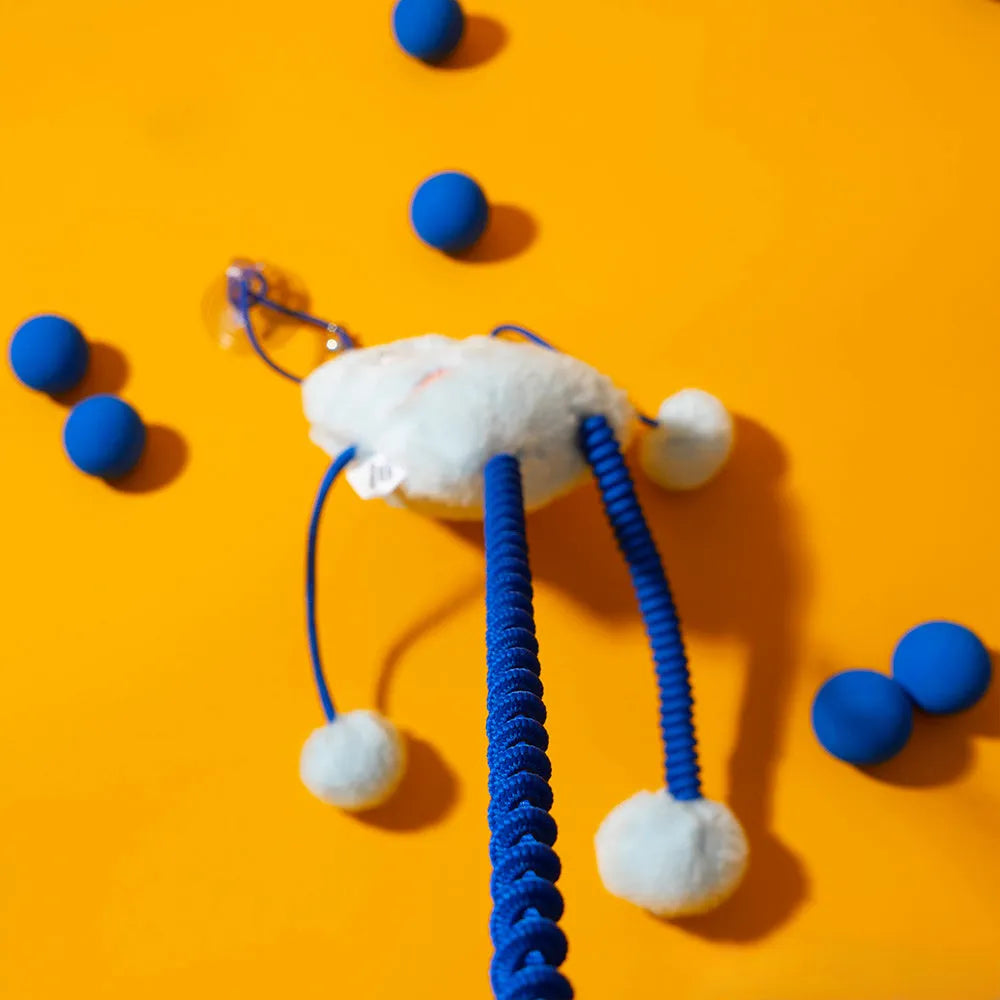Blue telescopic elastic cat toy with plush attachments and mint bell on 30cm by 30cm background