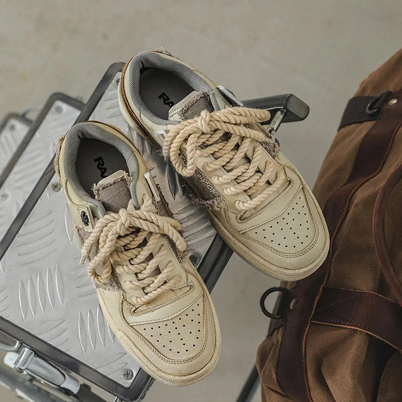 Beige low-top skateboard shoes with microfiber upper and rubber soles on white background