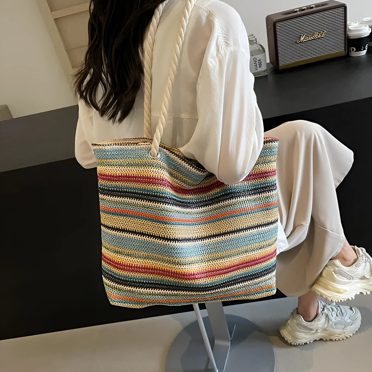 Blue woven straw and nylon shoulder bag with a large main compartment and zippered closure.