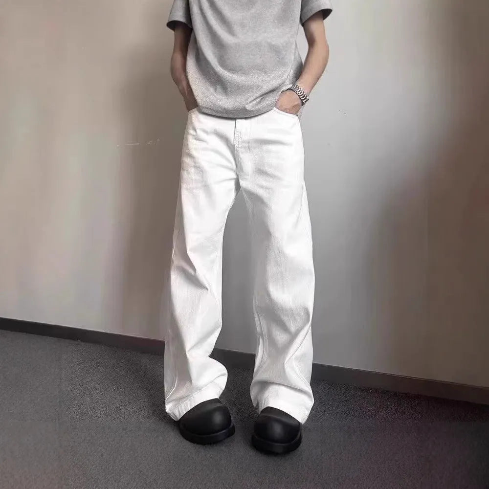 Men's white straight-leg denim jeans with a wide leg opening and a zip fly.