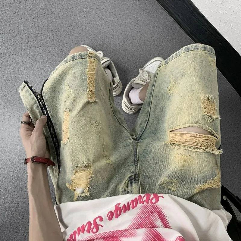 Man wearing blue ripped denim shorts with a yellow mud wash and button-fly closure
