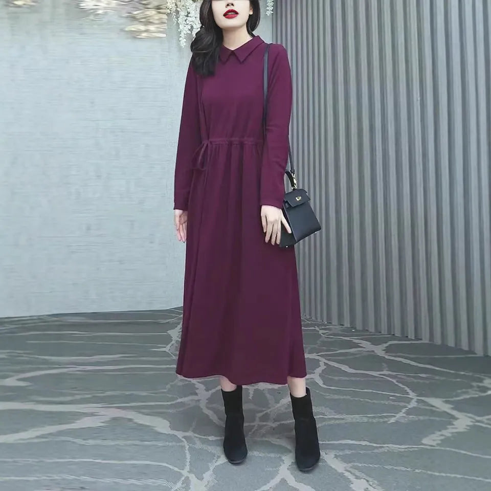Purplish red plus size long sleeve long skirt dress for women on a hanger.