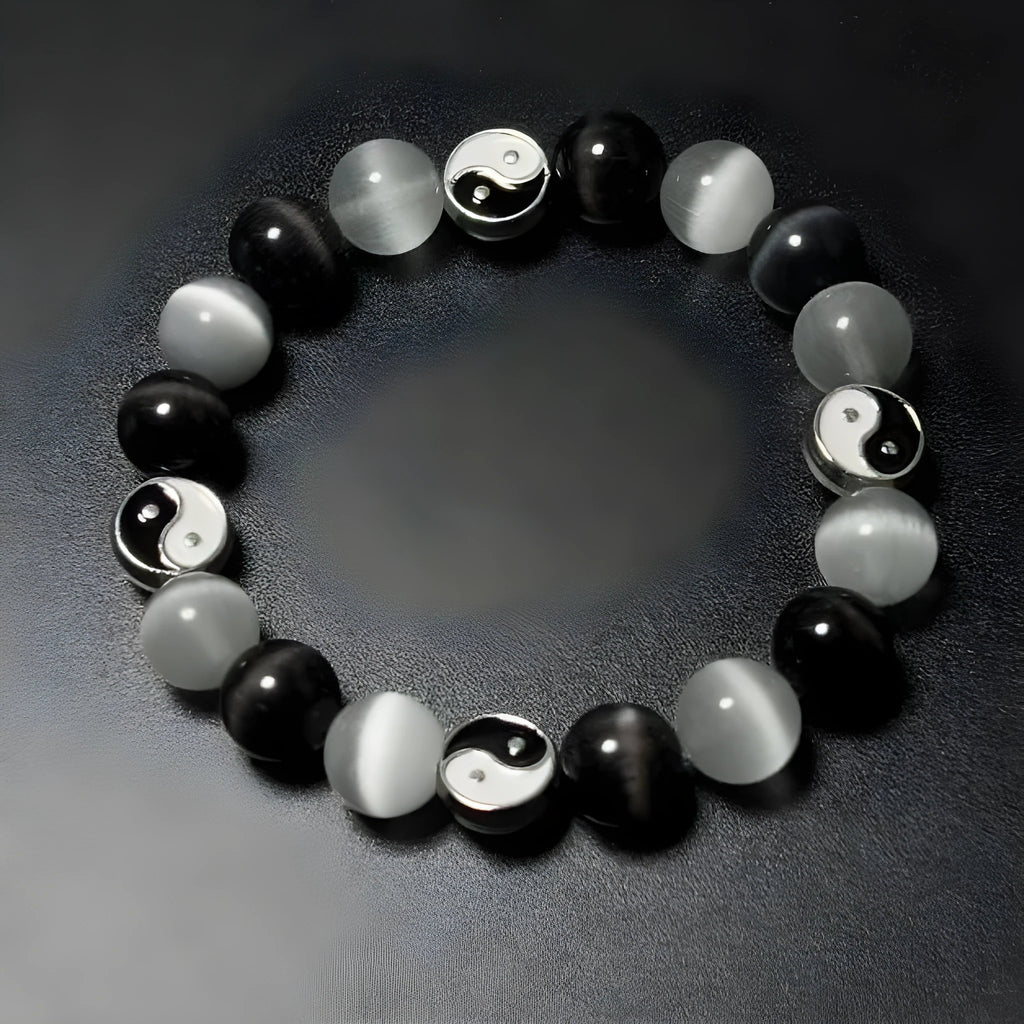 Opal and black agate Tai Chi bracelet with 10mm polished stone beads on a wrist.