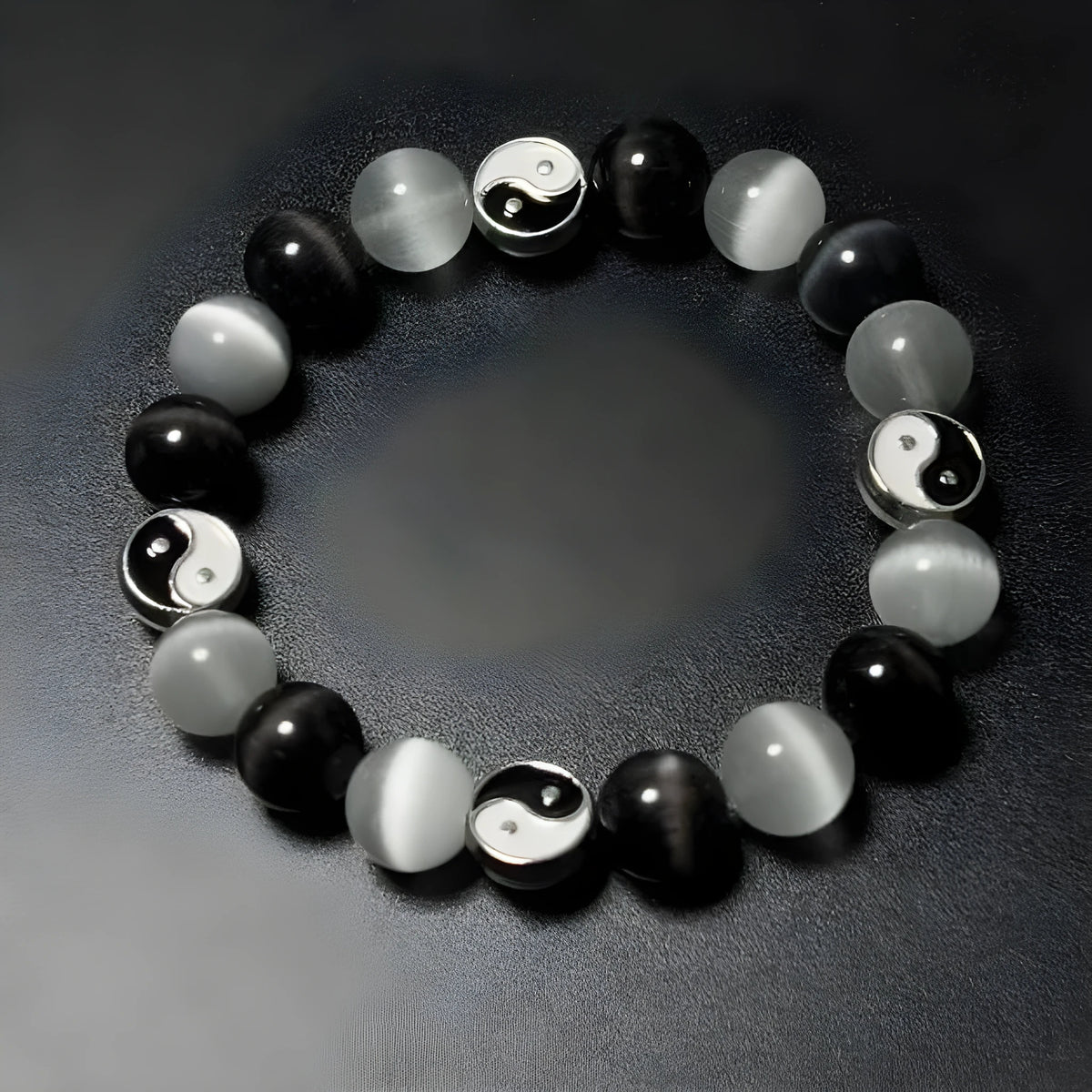 Opal and black agate Tai Chi bracelet with 10mm polished stone beads on a wrist.