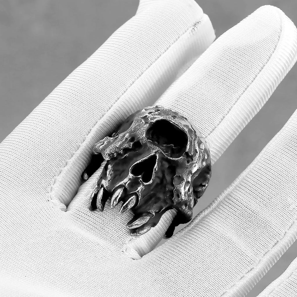 Silver-toned alloy ring with a detailed one-eyed skull design on a black background.