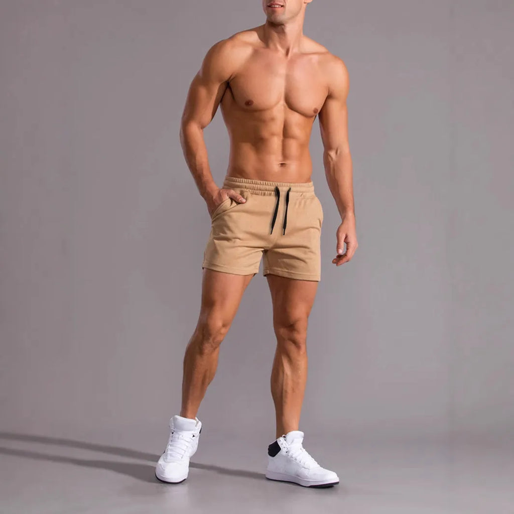 Three men's drawstring shorts in black, khaki, and light brown laid flat, showing loose fit and elasticated fabric.