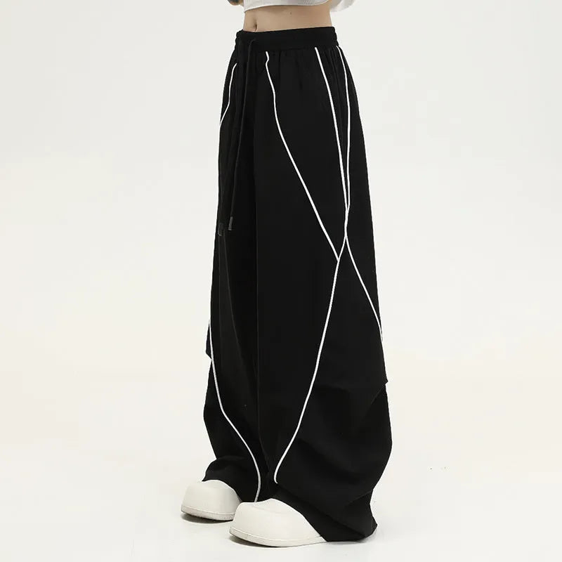 Black and white striped wide-leg hip hop trousers with front pleats on a mid-waist.