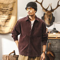 Men's black loose-fit long-sleeved corduroy shirt jacket on a hanger