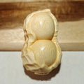 Solid bamboo peanut-shaped ornament with natural wood grain on wooden surface
