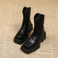 Women's black platform Martin boots with square toe, chunky sole, back zipper, and block heel.