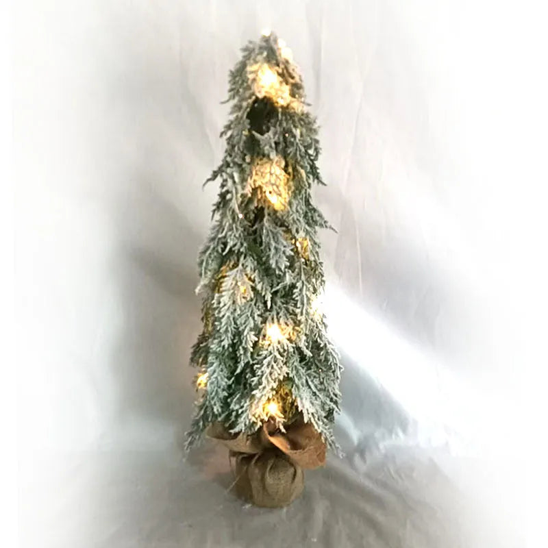 Small 24-inch artificial Christmas tree with LED lights and snow sprayer ornament on desktop