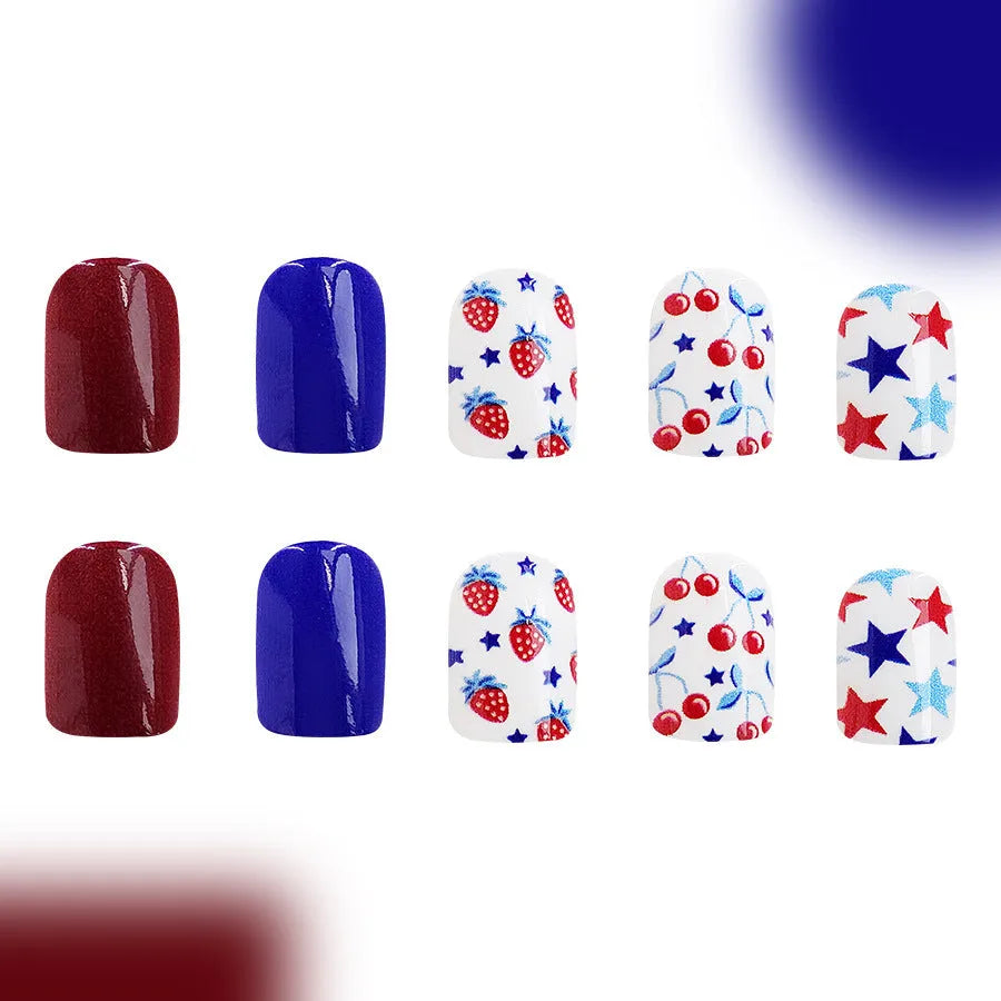 Short glossy red and blue strawberry cherry pattern false nail stickers laid out.
