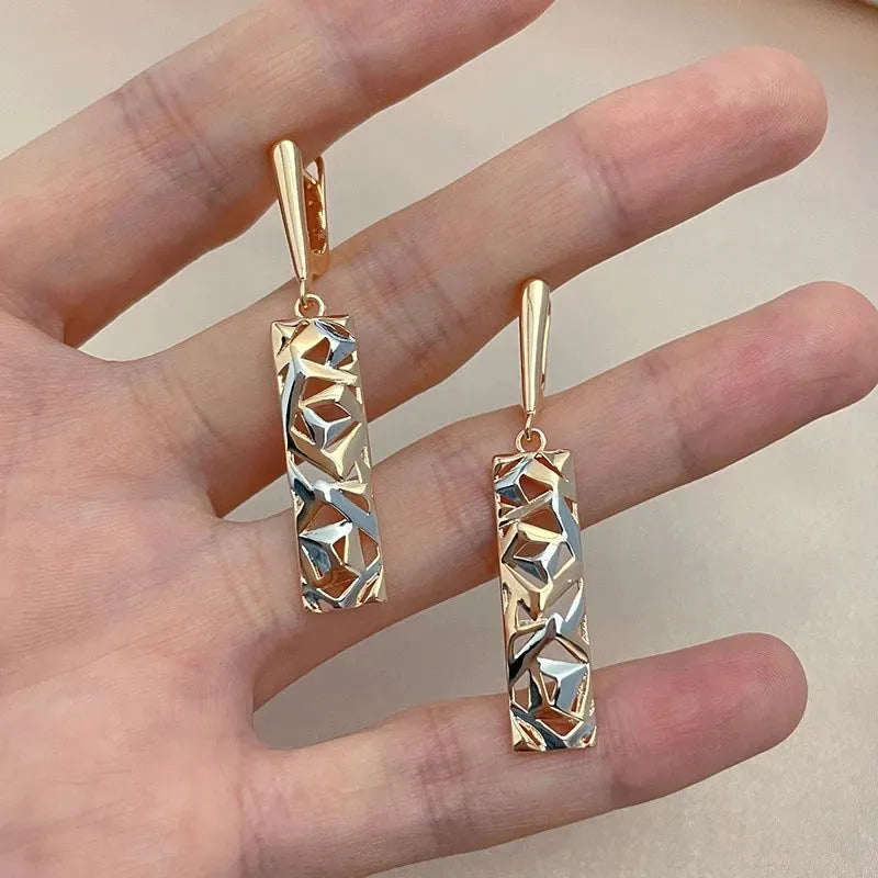 A pair of rectangular two-tone hollow stud earrings with an electroplated finish on a white background.