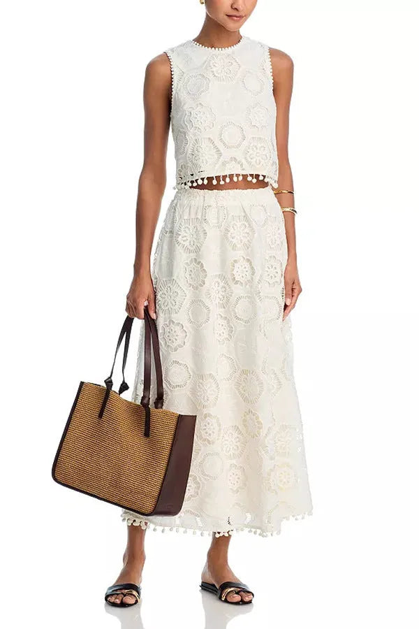 White women's sleeveless top and long skirt suit set with retro embroidery on a hanger