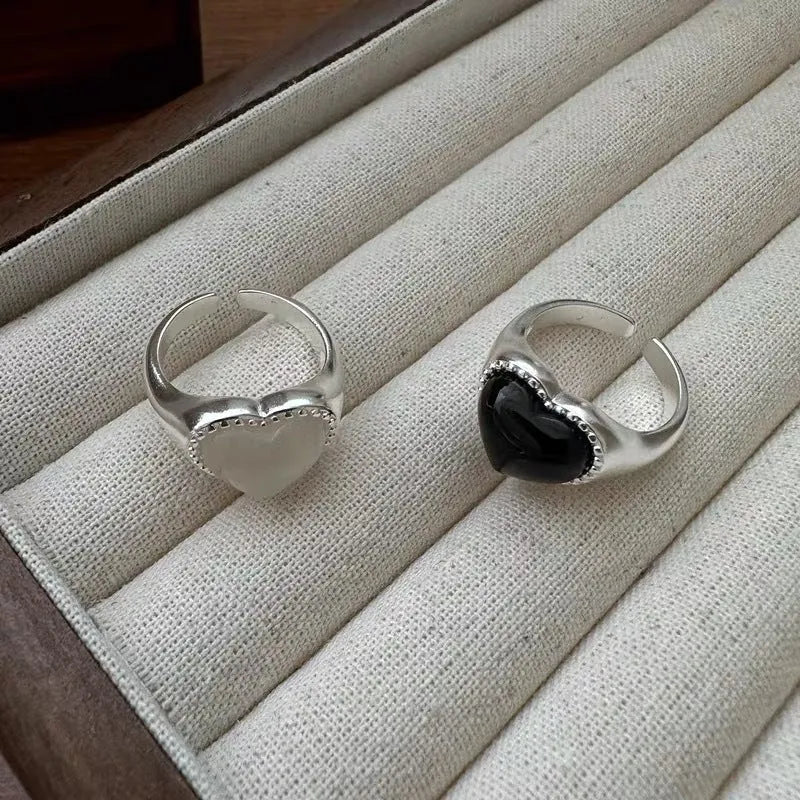 Sterling silver adjustable ring with black agate heart design on model's hand