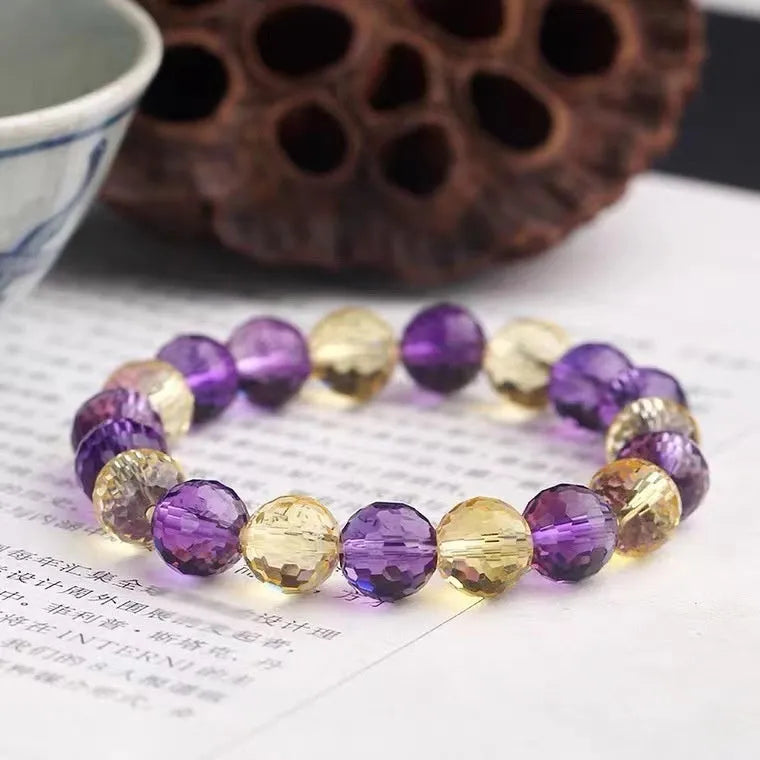 Hand-crafted ametrine bracelet with 128-facet cut crystal beads on a wrist.