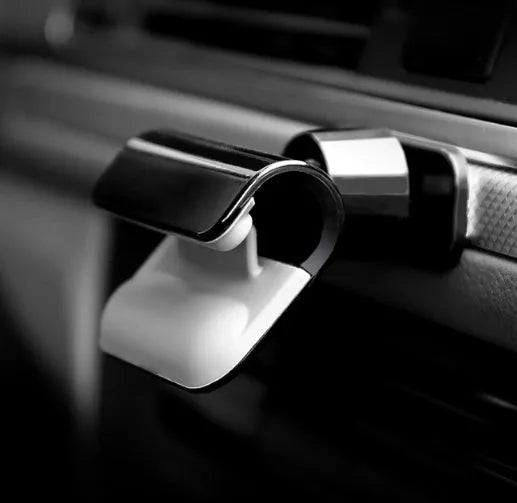Black universal car phone holder with 360-degree rotating head on dashboard